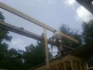 Carpenter setting a ridge beam over a new addition frame — Ice Dam Removal by Roofing Brothers in Pompton Lakes