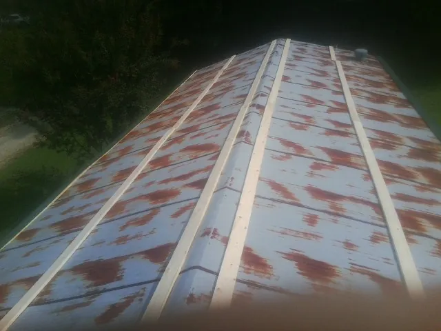 Rusted metal roof panels with new wood purlins before replacement — Storm Damage Roof Repair in Pompton Lakes by Roofing Brothers