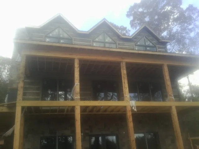 Dormers and porch framing on a large log home under construction — Roof Coating work by our crew in Pompton Lakes
