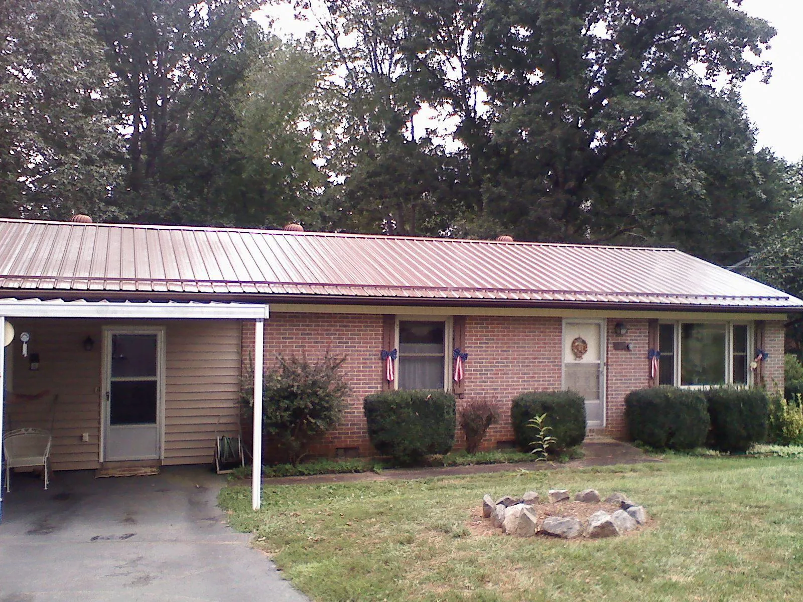 Bronze metal roof and carport on a brick ranch home — Roof Repair work by our crew in Pompton Lakes